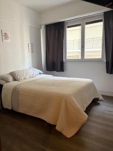 a bedroom with a large bed with a window at Departamento frente al casino in Mar del Plata +11 photos