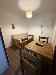 a dining room with a table and a couch at Departamento frente al casino in Mar del Plata