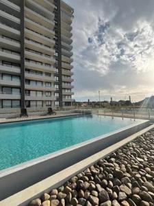 a large swimming pool in front of a building at Códomo Apartmento en Concon in Concón