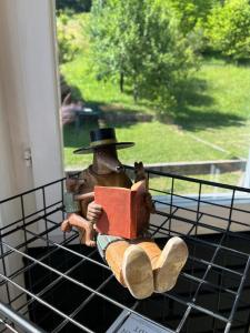 a figurine of a man in a hat reading a book at Nostalgia apartments in Jajce