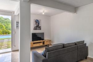 TV a/nebo společenská místnost v ubytování Appartement des 5 Trésors - piscine et vue panoramique