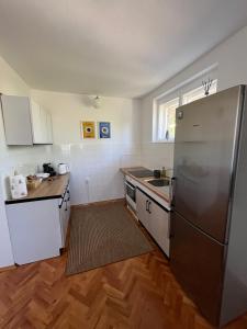 a kitchen with a stainless steel refrigerator and wooden floors at Nostalgia apartments in Jajce