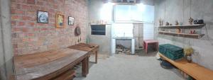 a room with a brick wall and a wooden bench at Pousada Siriemas in Cambara do Sul