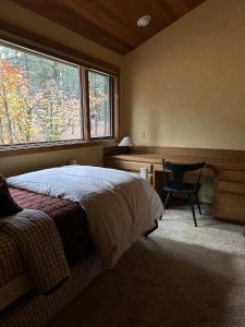 a bedroom with a bed and a desk and a window at Black Buttee Big Sister in Sisters +32 photos