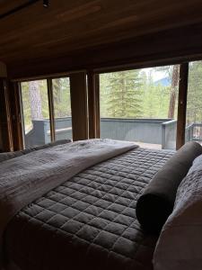 a large bed in a room with a large window at Black Buttee Big Sister in Sisters