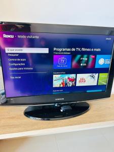 a flat screen tv sitting on top of a shelf at Apê Master 3 dorm espaçoso in São Carlos