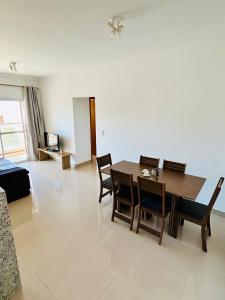a living room with a wooden table and chairs at Apê Master 3 dorm espaçoso in São Carlos +23 photos