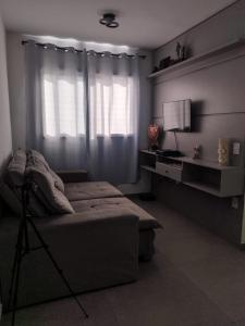 a bedroom with a bed and a television and a window at Quarto privativo Morumbi in São Paulo