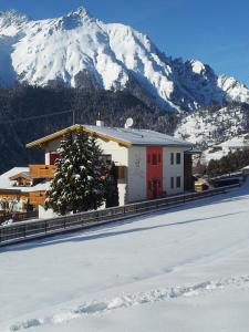 ein Gebäude mit einem Weihnachtsbaum vor einem Berg in der Unterkunft Haus Sagl in Nauders