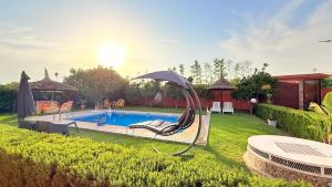 a backyard with a swimming pool and an umbrella at Villa Dayet Roumi House in Friday Market