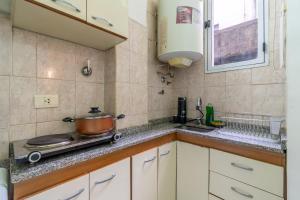a kitchen with a stove and a pot on the counter at Explora BA, depto céntrico junto al Obelisco con espacio de trabajo in Buenos Aires +33 photos