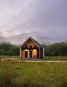 ein Haus im Scheunenstil auf einem Feld mit dem Himmel in der Unterkunft Hiker's Haven at Three Suns Cabins in Slade