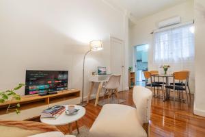 a living room with a tv and a table and chairs at Explora BA, depto céntrico junto al Obelisco con espacio de trabajo in Buenos Aires