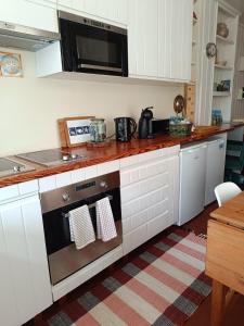 a kitchen with a stove and a microwave at Casa dos Narizes in Angra do Heroísmo +24 photos