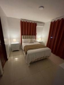 a bedroom with a large bed with red curtains at Alojamiento San Isidro in La Grúa