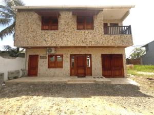 a house with wooden doors and a balcony at Glamar suits in Arboletes