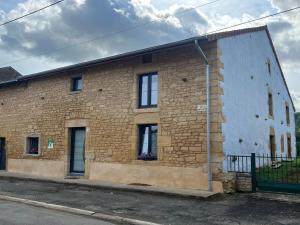 ein Backsteingebäude an der Straßenseite in der Unterkunft Campagne, confort moderne : Grand appartement rénové pour 8 pers. avec terrasse et jardin spacieux - FR-1-585-135 in Han-lès-Juvigny