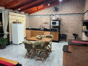 a kitchen with a wooden table and a white refrigerator at Quiosque do aconchego in Garibaldi