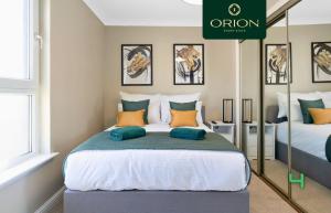 a bedroom with two beds and a mirror at LUXE Townhouse - LONGER STAYS and REDUCED PRICES Only by Visiting ORION SHORT STAYS, 4 Rooms, Fully Equipped, HOT-TUB, Games Room, EV Power Point, Centrally Located, Newly Renovated in Dundee