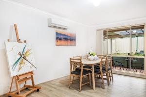 a dining room with a table and chairs at StayAU Cozy 3BR Suburban Retreat in Ingleburn in Ingleburn