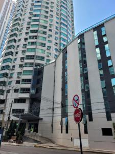 un panneau d'arrêt devant un grand bâtiment dans l'établissement Flat beira mar com estacionamento apto 1515, à Balneário Camboriú