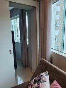 un salon avec un canapé et une grande fenêtre dans l'établissement Flat beira mar com estacionamento apto 1515, à Balneário Camboriú