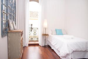 Un dormitorio blanco con una cama y una ventana. en Malaga Center Flat Luxury, en Málaga