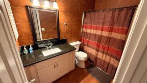 a bathroom with a sink and a toilet and a shower at J10 Private Room with Smart TV Near Everything in Orlando