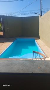 a blue swimming pool with a chair next to it at Chácara Stella in Ribeirão Preto