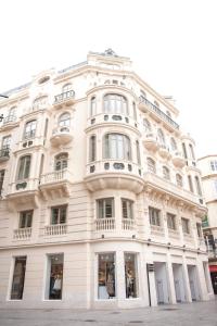 a large white building with windows on a street at Malaga Center Flat Luxury in Málaga