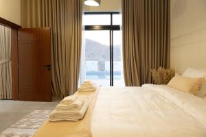 a hotel room with two beds with towels on them at Sifah Breeze in Dhīqdah +34 photos