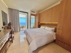a bedroom with a large bed and a view of the ocean at Zantamar Penthouse 603B, right on the beach in Cruz de Huanacaxtle