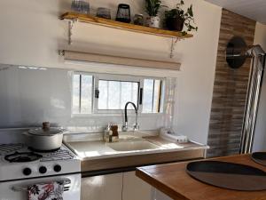 a kitchen with a sink and a stove and a window at Rincon de los Michis in Barra del Chuy
