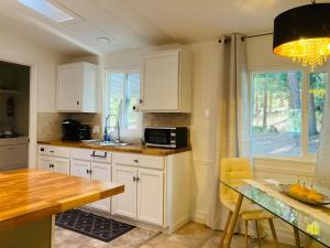 a kitchen with white cabinets and a table with a microwave at Dafna, Unit 5 in Cromberg