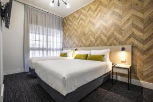 a bedroom with a large bed and a window at Nightcap at Sylvania Hotel in Campbellfield