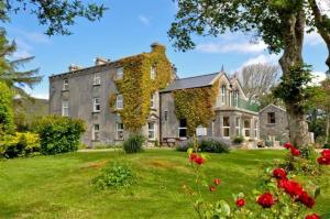 a large stone house with ivy growing on it at Errisbeg House B&B in Roundstone