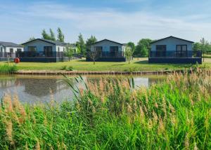 a row of houses next to a body of water at Serenity Lakes in Fleet