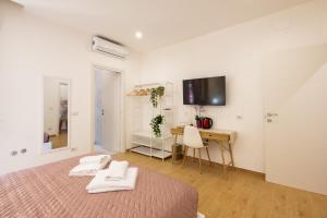 a bedroom with a bed and a desk and a television at San Pietro Roma Suite in Rome