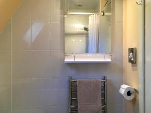 a bathroom with a shower and a mirror and a towel at Heather Lodge in Glenurguhart