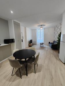 a living room with a black table and chairs at Appartement Confort Cholet in Cholet