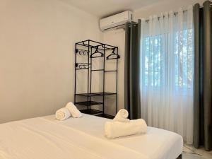 a bedroom with two towels on a bed with a window at Vila 44 in Sarandë