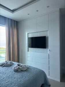 um quarto com uma cama com uma cómoda e uma televisão em Apartamento Praia do Forte, Cabo Frio, Frente mar em Cabo Frio mais 32 fotografias