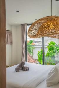 a bed with a towel on it with a window at Villa Casa Sea Salt in Denpasar