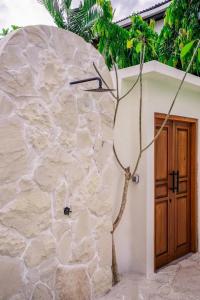 a stone building with a tree next to a door at Villa Casa Sea Salt in Denpasar