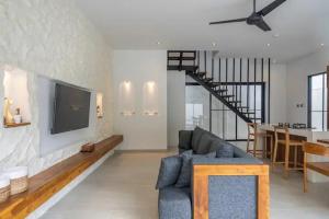 a living room with a couch and a tv on a wall at Villa Casa Sea Salt in Denpasar