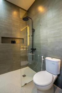 a bathroom with a toilet and a glass shower at Villa Casa Sea Salt in Denpasar +12 photos