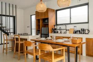 a dining room with a table and chairs and a kitchen at Villa Casa Sea Salt in Denpasar
