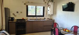 a kitchen with a stove and a sink and a table at Los Aromos'home in Chacras de Coria