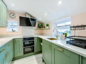 a kitchen with green cabinets and a sink at The Anchor in Scarborough