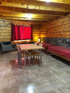 ein Esszimmer mit Tisch und Stühlen und einer Couch in der Unterkunft Apart al Lago in Villa Pehuenia